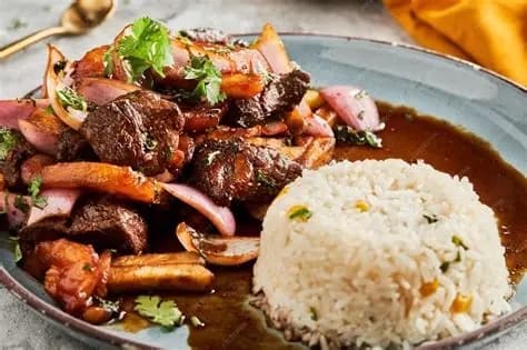 El Galan Peruvian dish with grilled meat, onions and rice served in Jackson Heights Queens