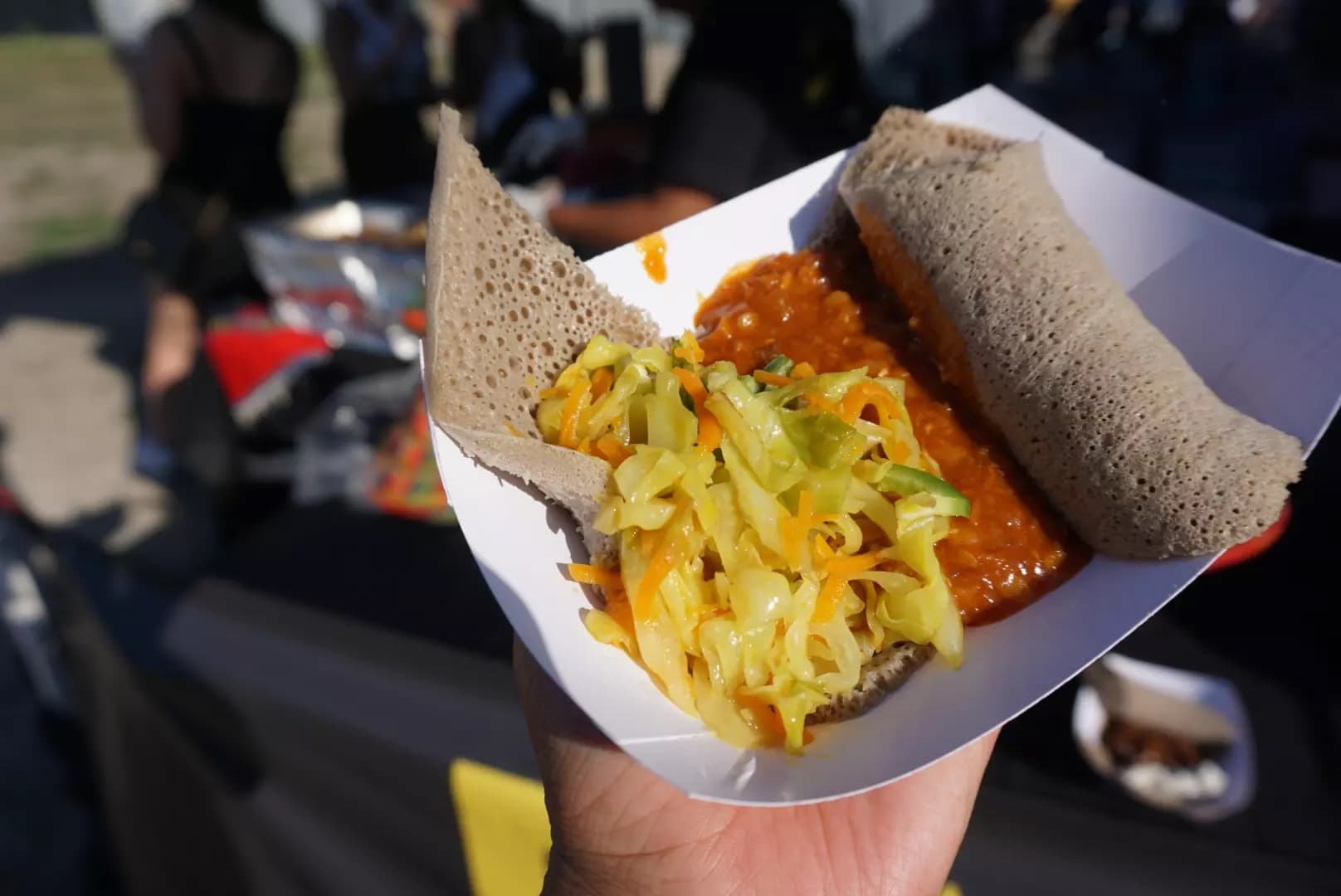 Queens Night Market handheld street food in injera flatbread at Flushing Meadows Corona Park