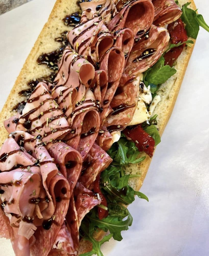 Sorriso Italian Salumeria hero sandwich in Astoria piled with cured meats, fresh mozzarella, arugula, roasted peppers, and balsamic